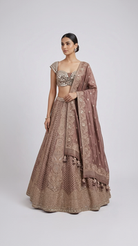 Women's brown embroidered lehenga set with mirror work blouse, flared skirt and embroidered dupatta for weddings.