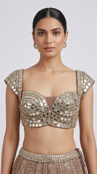 Close-up of mirror embroidered blouse with intricate handwork on a designer brown lehenga set.