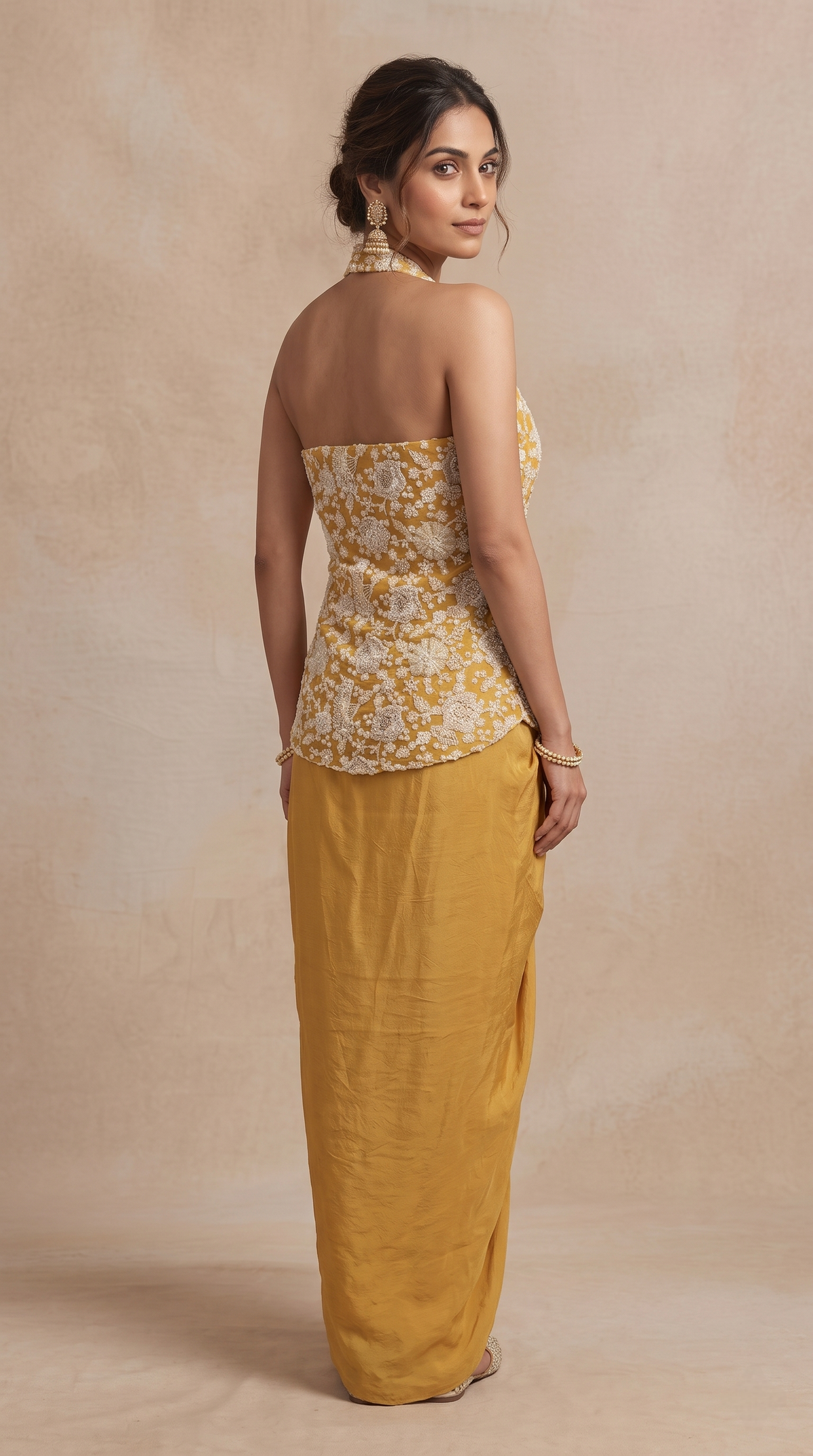 Yellow pleated skirt and sequin embroidered halter top ethnic outfit, ideal for sangeet night, mehndi, cocktail parties and festive celebrations.