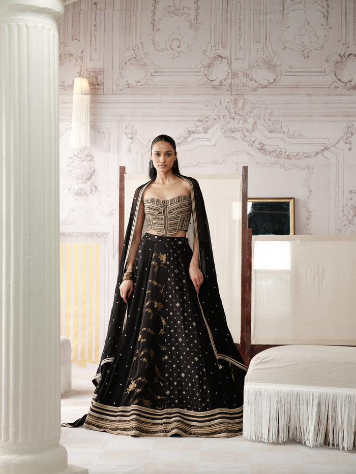 Black And Gold Banarasi lehenga choli featuring intricate gold embroidery, delicate motifs and a richly detailed border, paired with a matching embellished dupatta.